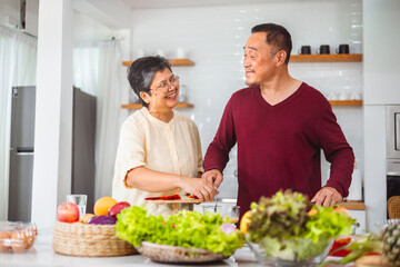 Obraz na płótnie Canvas Asian elderly couple cooking in kitchen to prepare dinner