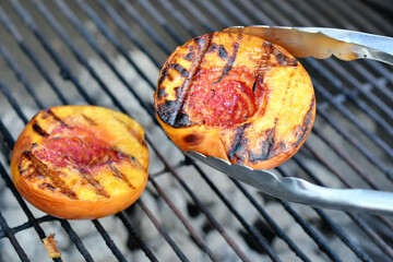 Grilling peaches  on a charcoal grill for easy summer dessert. 