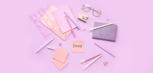 Sticky note with word DONE, eyeglasses and stationery on lilac background