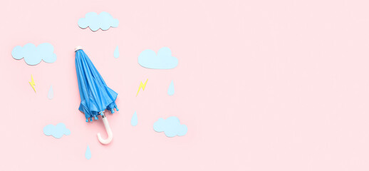 Small umbrella with paper clouds, rain drops and lightnings on pink background. Weather forecast concept