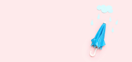 Small umbrella with paper cloud and rain drops on pink background with space for text. Weather forecast concept