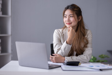 Financial Business asian women analyze the graph of the company's performance to create profits and growth, Market research reports and income statistics, Financial and Accounting concept.	