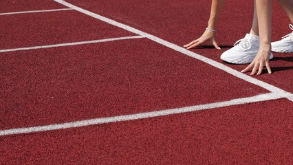 The sprinter starts for a run. Side view of an athlete starting a sprint on a treadmill. The runner uses the starting block to start his run on the race track.