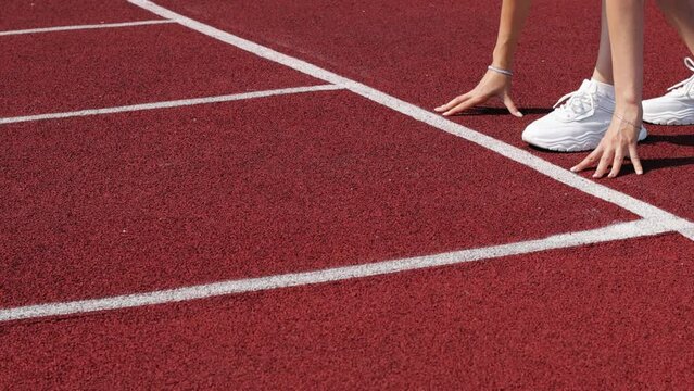 The sprinter starts for a run. Side view of an athlete starting a sprint on a treadmill. The runner uses the starting block to start his run on the race track.