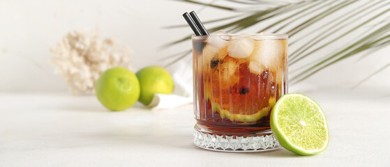 Glass of cold Cuba Libre cocktail on light table