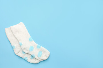 Pair of warm socks on color background