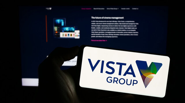 Stuttgart, Germany - 06-23-2023: Person holding cellphone with logo of company Vista Group International Limited on screen in front of business webpage. Focus on phone display.