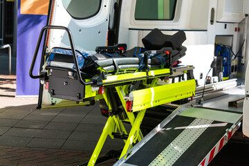 Open doors of an emergency car with yellow trolley for transporting patients