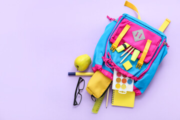 Color school backpack with pencil case, eyeglasses and apple on lilac background