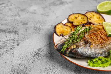 Plate with tasty grilled dorado fish on light background