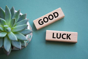 Good luck symbol. Wooden blocks with words Good luck. Beautiful grey green background with...