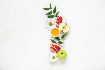 Composition with bowl of honey, ripe fruits, flowers and plant leaves on light background. Rosh...