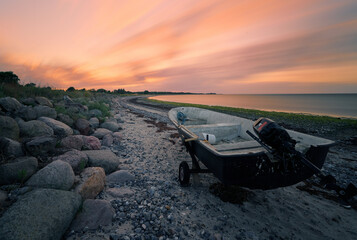 Kleines Motorboot liegt am steinigen Ostsee-Strand von Ulvshale auf der dänischen Insel Møn vor...