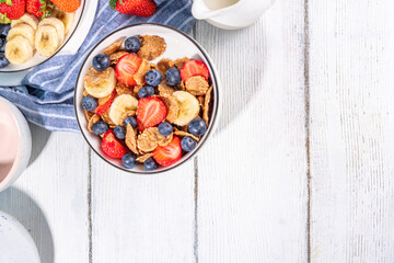 Healthy vitamin diet summer breakfast. Cereal Multigrain  flakes with yogurt or milk and strawberries, blueberries, on kitchen table copy space