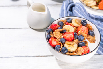 Healthy vitamin diet summer breakfast. Cereal Multigrain  flakes with yogurt or milk and strawberries, blueberries, on kitchen table copy space