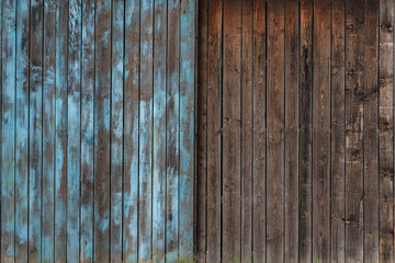 Gates from old weathered boards arranged vertically. One half painted blue.