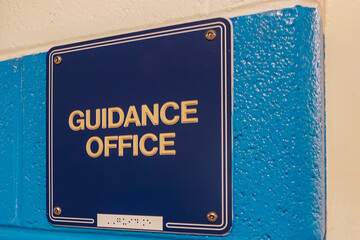 Guidance Office, counselor office, sign with braille, on blue wall at door to school office.
