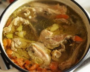 Broth is cooked in a saucepan. A fatty dish is being prepared on the stove. Cooking food at home, delicious dinner. Home food