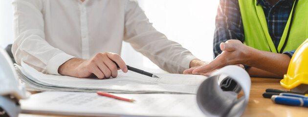 architect explaining client demand plan of construction on the table to contractor.