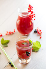 fresh berry juice from red and black currant, on a wooden table