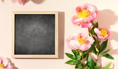 vintage chalk board and spring peony flowers top view