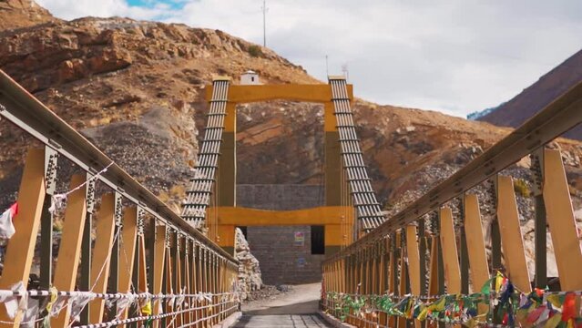 View of the Chicham bridge between Kibber and Chicham villages at Spiti Valley in Himachal Pradesh, India. Prayer flags wave on the side of the bridge above the mountain valley. Asia's highest bridge.