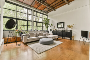 a living room with wood flooring and large windows that look out onto the trees in the forest behind it
