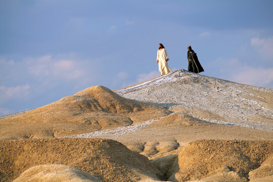 Jesus and Devil on a hill in a Judean desert. Biblical concept.
