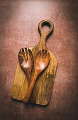 wooden spoon, with cloves, for salad, two pieces, natural wood, with cutting board, food background, wallpaper, top view,