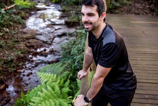 A happy man observing a water spring in a forest in the Atlantic Rainforest in Brazil