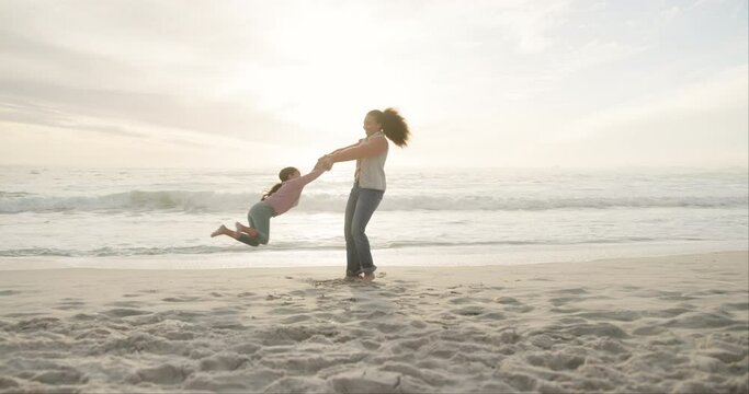 Playing, swinging and a mother with a child at the beach for bonding, break and summer together. Smile, holding hands and mom being playful with a little girl for fun at the sea during a holiday