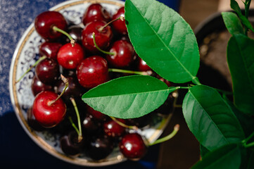 Cherries with leaves on plates Ripe ripe cherries. Sweet red cherries. View from above. Cherries. fruit background