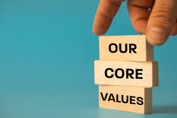 our company core values, Concept, Hand arranging wooden blocks with text, Our Core Values, Beautiful blue background, copy space