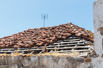 Desolate Charm: Abandoned Rooftop with Missing Tiles and Antenna