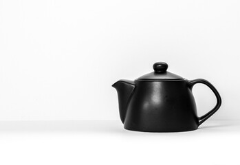 black ceramic teapot against a white background