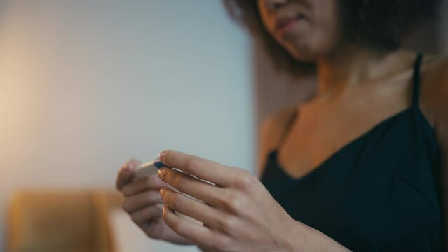 Happy African American woman sitting with positive pregnancy test in hands