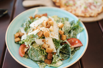 Caesar salad on table in cafe. Delicious vegan salad with nut parmesan. Fresh and hearty food 