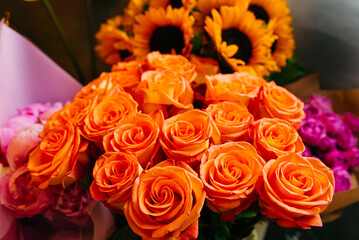 Orange roses and sunflowers in a huge bouquet, close-up