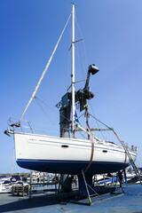 The yacht lifted ashore by a sailboat lift for the maintenance of the underwater part of the hull
