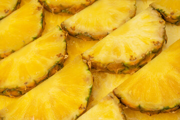 Pineapple juicy yellow slices as a background.