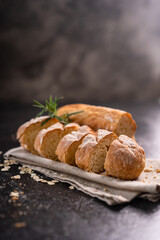Sliced baguette bread on wooden coaster and rustic background. Artisan Sourdough bread.