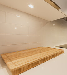 espace vide sur un comptoir avec une planche à découper en bois de bambou avec une lumière dans le cabinet au dessus