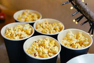 Cheese-flavoured popcorn in paper black cups