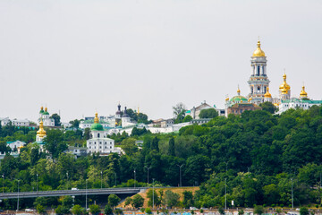 Fototapeta na wymiar In summer, through the branches of trees, you can see the Kyiv Lavra