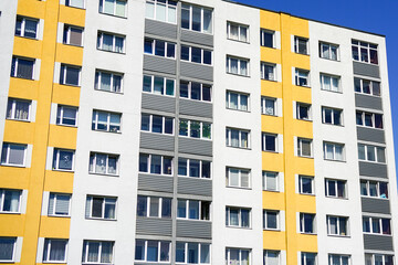 Renovated and insulated multistorey apartment building against a blue sky background