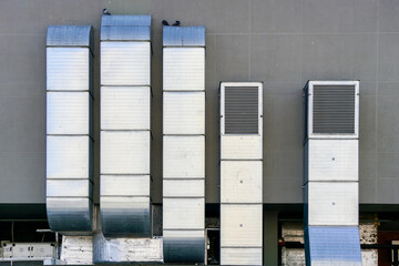 Galvanized tin square ventilation system pipeworks on a gray wall background