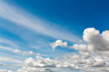 White clouds on a summer blue sky in cartoon style for background or wallpaper design. The whiteness of round clouds in a blue sky. High clouds in the sky.