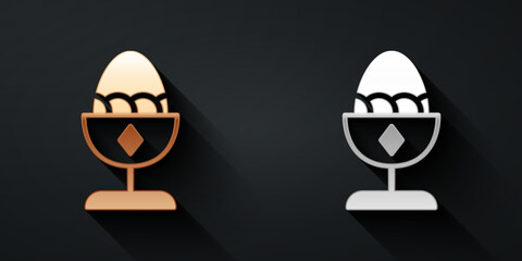 Fototapeta premium Gold and silver Chicken egg on a stand icon isolated on black background. Long shadow style. Vector