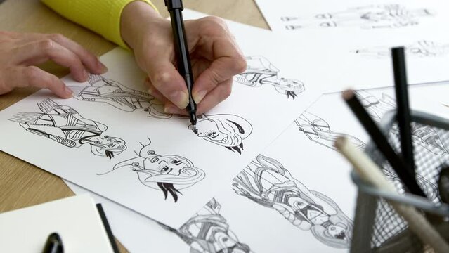 An artist draws characters for computer games. Illustrator drawing sketches on paper. Animation design studio. Animator designer Development video game character.