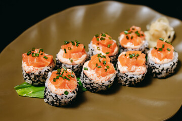 Sushi Tartaro Roll on the green plate on the black background